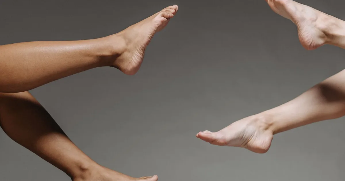 Bare feet of several people side by side on a neutral backdrop — best insoles for flat feet, Podiatrist Tested