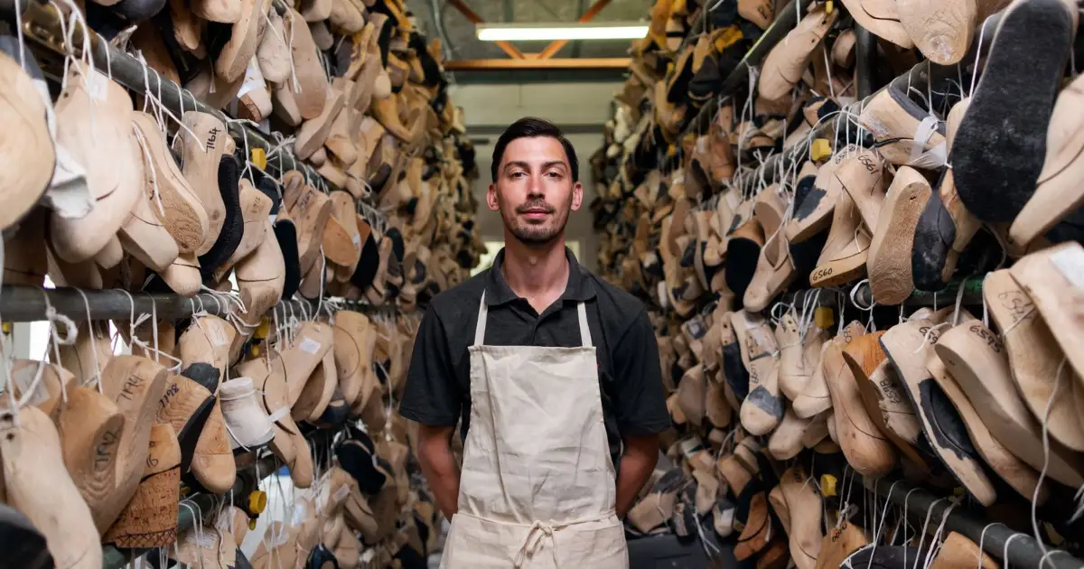 Shoemaker among rows of wooden shoe lasts — best insoles for standing all day, Podiatrist Tested