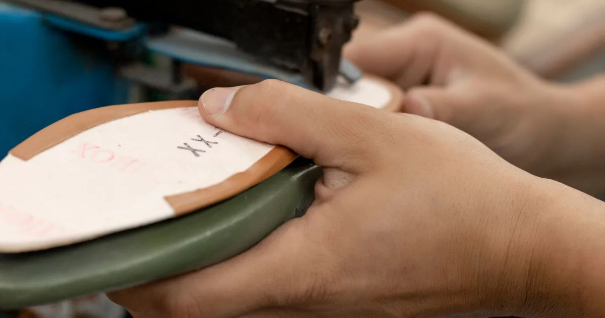 Hands shaping a boot sole on workshop machinery — best insoles for work boots, Podiatrist Tested