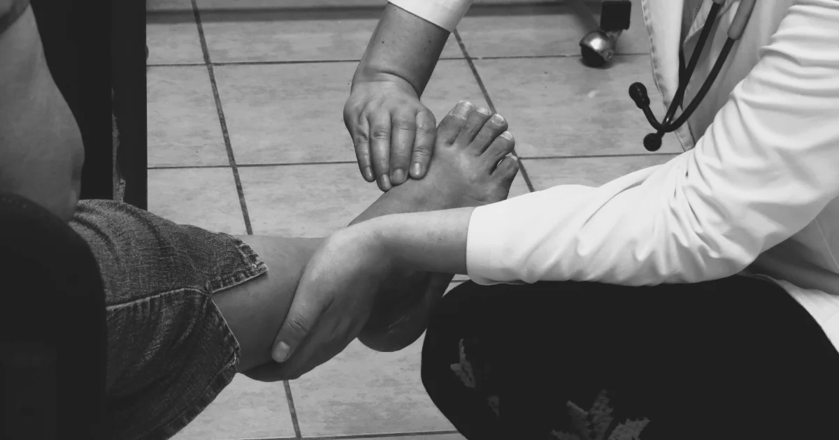 A clinician examining a patient foot during a consultation - best shoes for diabetics, Podiatrist Tested
