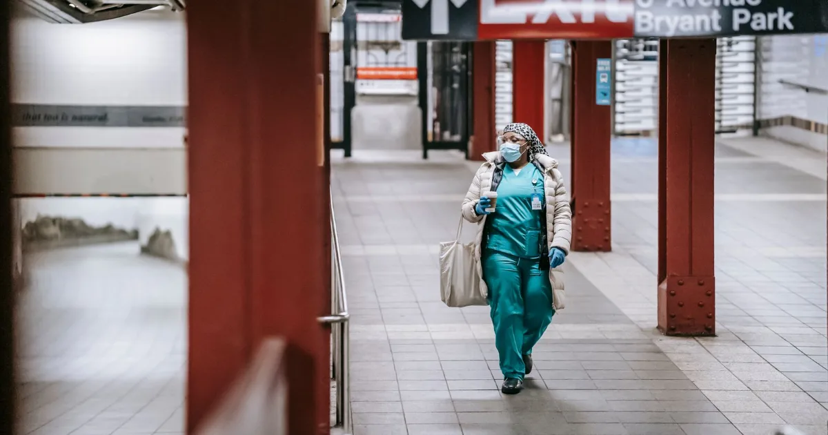 Nurse in scrubs walking through a transit station after a shift — best shoes for nurses, Podiatrist Tested