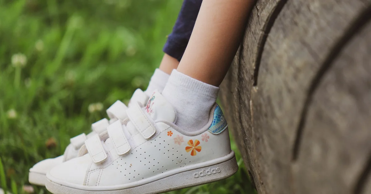 A child's feet in fastened trainers outdoors - best shoes for kids, Podiatrist Tested