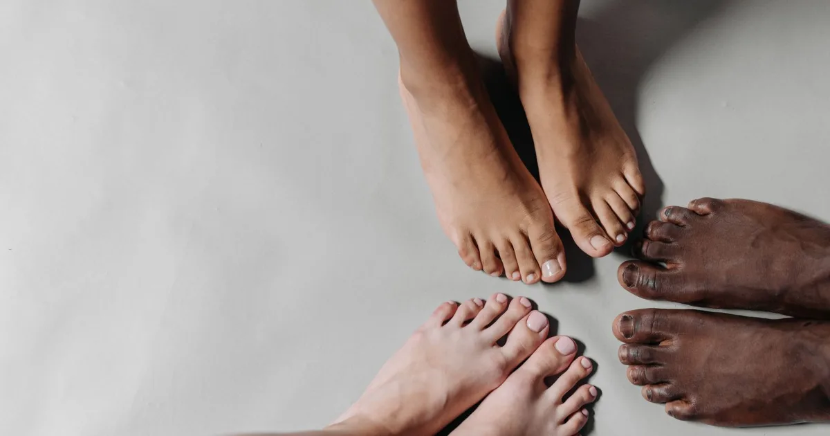 Bare feet standing on a pale studio surface, forefoot in view — best shoes for metatarsalgia, Podiatrist Tested