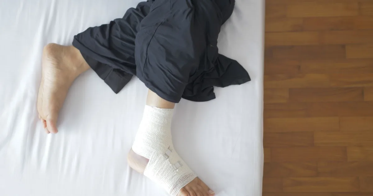 Bandaged foot resting on a bed during recovery — best shoes for stress fractures, Podiatrist Tested