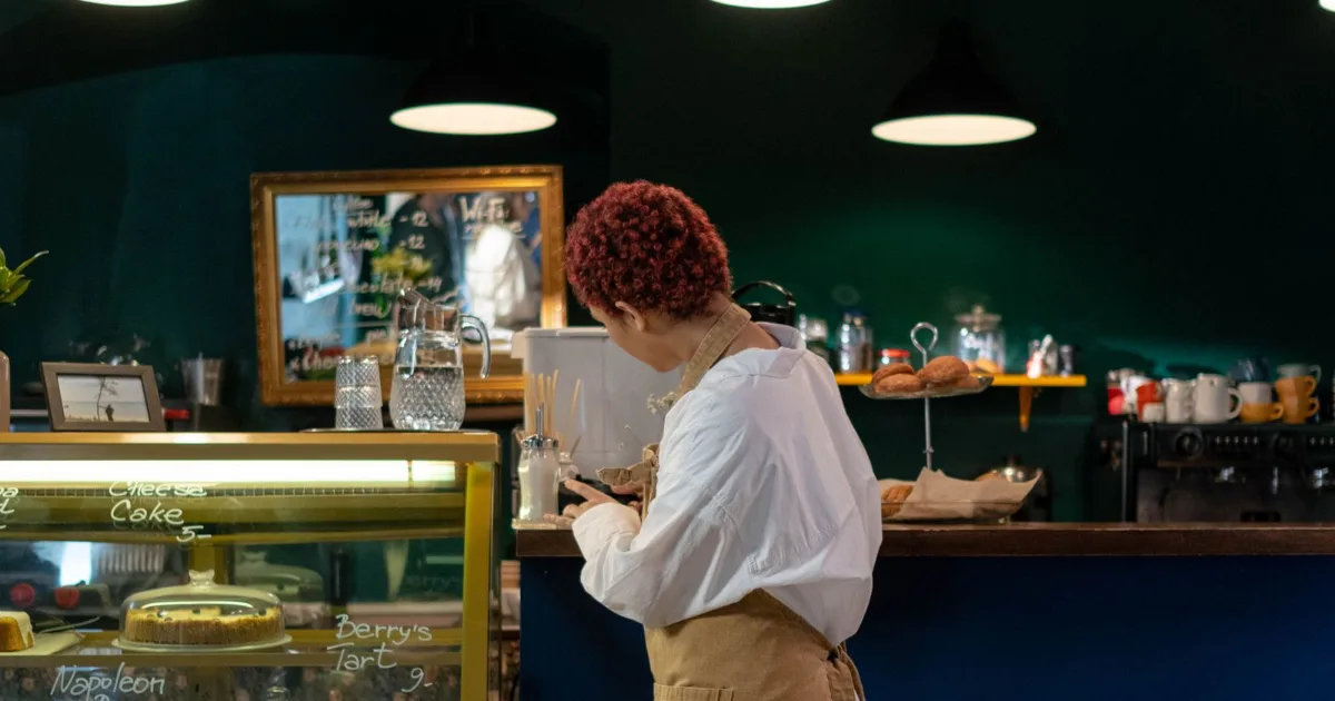 Worker standing behind a cafe counter during a shift — best work shoes for women, Podiatrist Tested