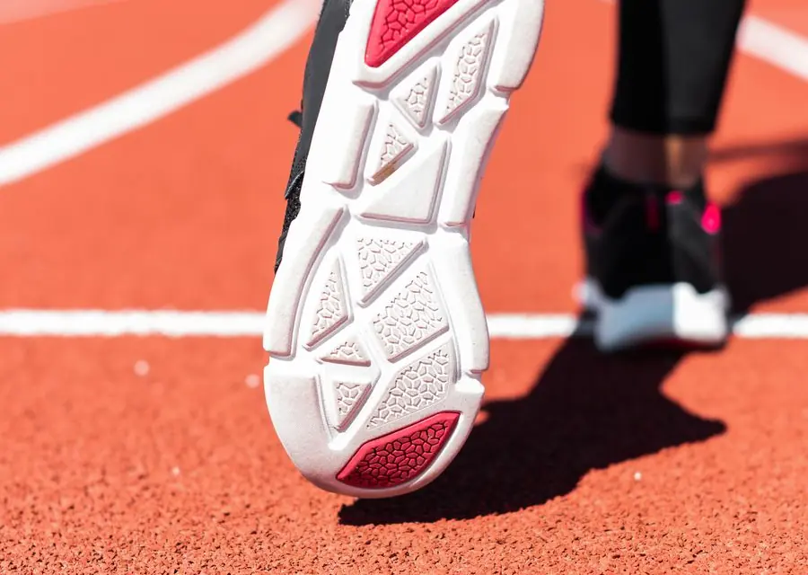 Running shoe outsole on a red running track
