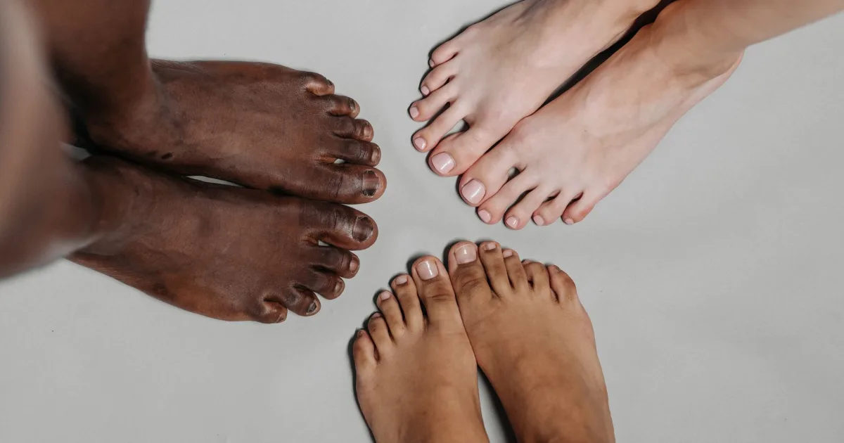 Three pairs of bare feet showing natural toe splay — wide toe box shoes, Podiatrist Tested